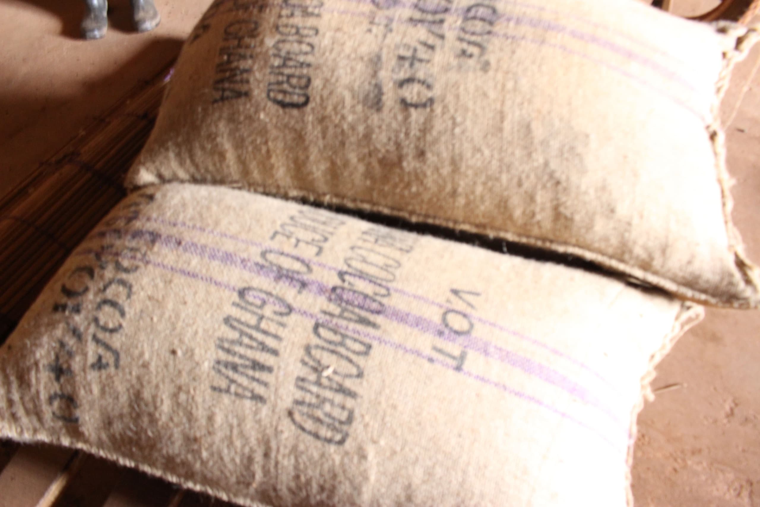 Sacks stamped Ghana Cocoa Board stacked and tied in a buying-centre store
